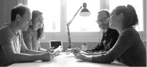 2 Hommes Et 2 Femmes Assis Autour D’une Table